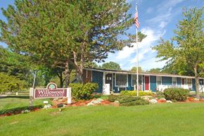 Lansing apartment for rent - A sign that says Willowood Apartments is in front of a building.