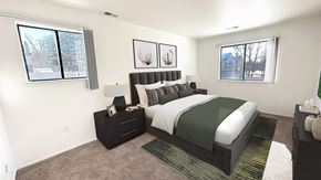 Canton apartment for rent - A bedroom with a large bed and two windows.