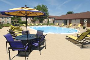 Canton apartment for rent - A pool with chairs and an umbrella in the foreground.