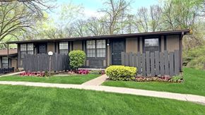 Toledo apartment for rent - A house with a grey fence and a green lawn.