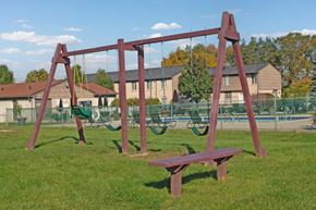 Howell apartment for rent - A swing set with a red frame and a bench in the foreground.