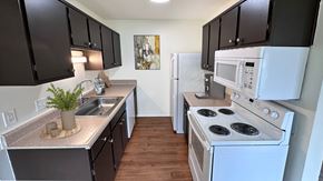 Howell apartment for rent - A kitchen with black cabinets and white appliances.