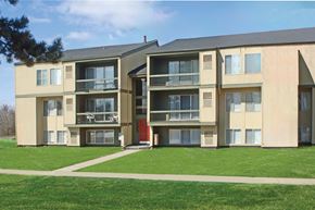 Flint apartment for rent - A large apartment building with a red door and balconies.