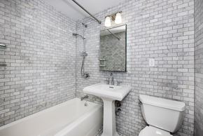 New York apartment for rent - A white sink and toilet in a tiled bathroom.
