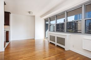 New York apartment for rent - A large empty room with wooden floors and white walls.