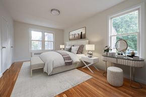 Dobbs Ferry apartment for rent - A well-lit bedroom with a large bed and a desk with a chair.
