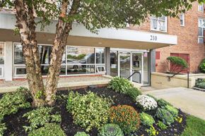 Long Beach apartment for rent - A building with the number 210 on it has a landscaped garden in front.