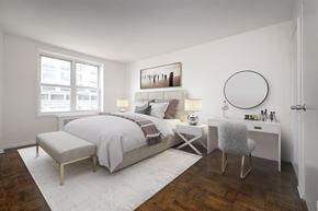Long Beach apartment for rent - A bedroom with a large bed, a chair, and a table with a mirror.