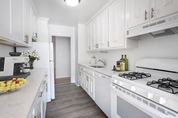 Long Beach apartment for rent - A white kitchen with a stove and a bowl of fruit on the counter.