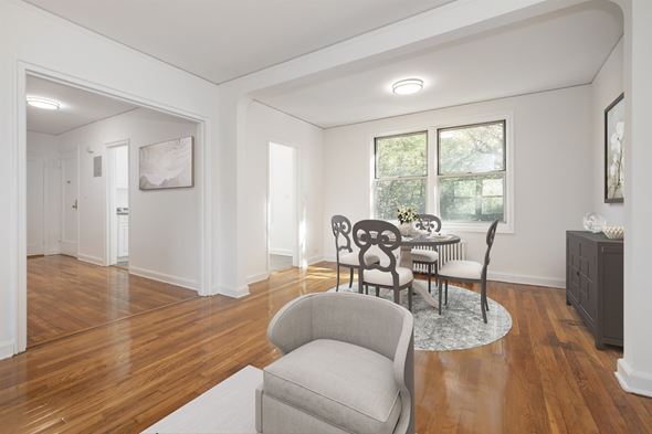 White Plains apartment for rent - A living room with a grey armchair and a table with chairs.