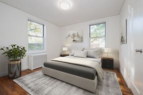 White Plains apartment for rent - A bedroom with a large bed and a plant in a planter.