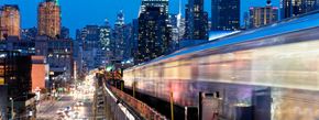 New York apartment for rent - A train is passing through a city at night.
