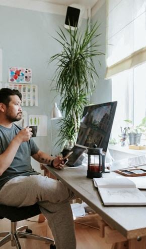 New York apartment for rent - A man is sitting at a desk with a cup in his hand.