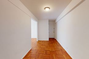 Forest Hills apartment for rent - A long hallway with a wooden floor and white walls.