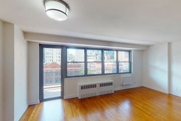 New York apartment for rent - A room with a window overlooking a cityscape.