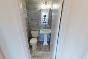 New York apartment for rent - A bathroom with a toilet, sink, and mirror.