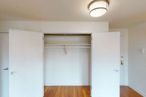 New York apartment for rent - A white room with a wooden floor and a white door.