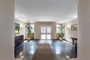 New York apartment for rent - A spacious room with a large rug in the middle and a door at the end.
