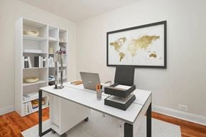 White Plains apartment for rent - A laptop is on a desk with a world map on the wall.
