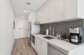 Park City apartment for rent - A modern kitchen with white cabinets and stainless steel appliances.