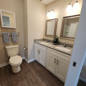 Kansas City apartment for rent - A bathroom with a toilet, sink, and mirror.