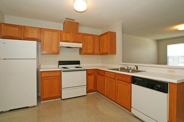 Goldsboro apartment for rent - A kitchen with wooden cabinets and white appliances.