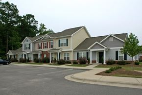 Goldsboro apartment for rent - A row of houses with a car parked in front of the first house.