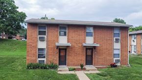 St. Louis apartment for rent - A brick building with a green lawn in front.