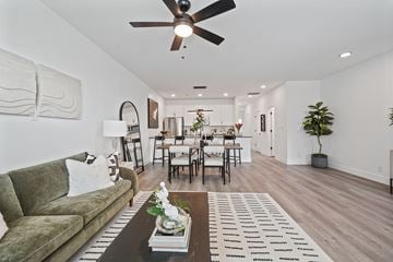 Knoxville townhouse for rent - A living room with a green couch and a coffee table with a vase of flowers on it.