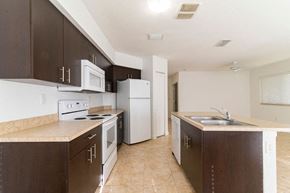 Homestead apartment for rent - a kitchen with white appliances and brown cabinets