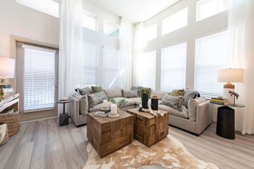 Orlando apartment for rent - a living room with a couch and tables in front of windows