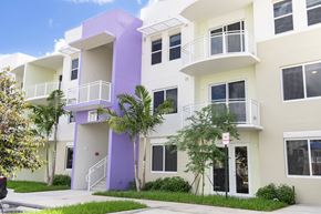 Miami apartment for rent - A white and purple building with balconies and windows.
