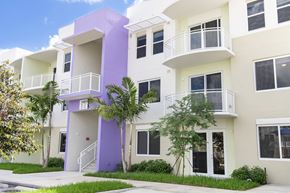 Miami apartment for rent - A white and purple building with balconies and windows.