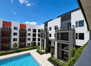 Orlando apartment for rent - A modern apartment complex with a pool in the courtyard.