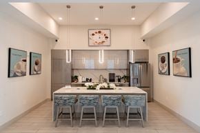Miami apartment for rent - A modern kitchen with a dining table and chairs.