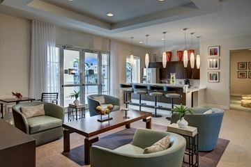 Pompano Beach apartment for rent - A living room with a green chair and a brown coffee table.
