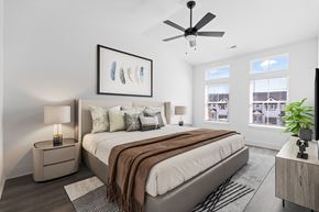 Knoxville townhouse for rent - A bedroom with a large bed, a ceiling fan, and a painting on the wall.