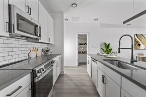 Knoxville townhouse for rent - A modern kitchen with white cabinets and black countertops.