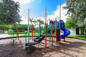 Homestead apartment for rent - a playground with a blue and red slide and benches
