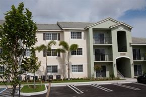 Homestead apartment for rent - a large building with palm trees in front of it