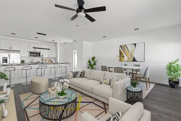 Knoxville apartment for rent - A modern living room with a white sofa set, a glass coffee table, and a ceiling fan.