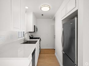Santa Cruz townhouse for rent - A kitchen with white cabinets and a black fridge at Westmont Place Townhomes Apartments, Santa Cruz, 95060