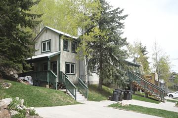 Park City apartment for rent - a house on a hill with trees and a sidewalk