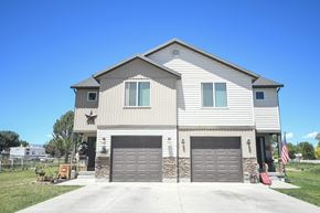 Vernal apartment for rent - a white house with two garage doors and a blue sky