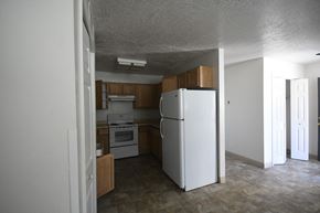 Wendover apartment for rent - an empty kitchen with a refrigerator and a stove in it