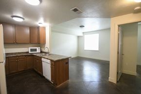 Park City apartment for rent - an empty kitchen with wooden cabinets and white appliances and a window