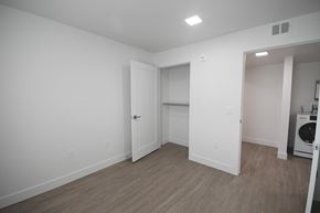 Park City apartment for rent - a bedroom with white walls and wood flooring and a laundry room