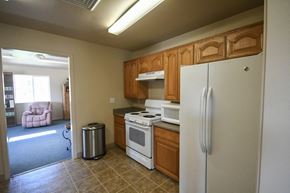 Logan apartment for rent - a kitchen with white appliances and wooden cabinets and a refrigerator