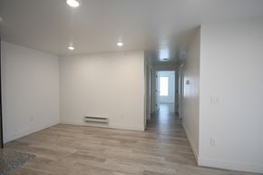 Park City apartment for rent - a living room and hallway with white walls and wood flooring