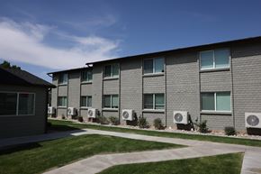 Vernal apartment for rent - A building with grey walls and multiple air conditioning units in front.